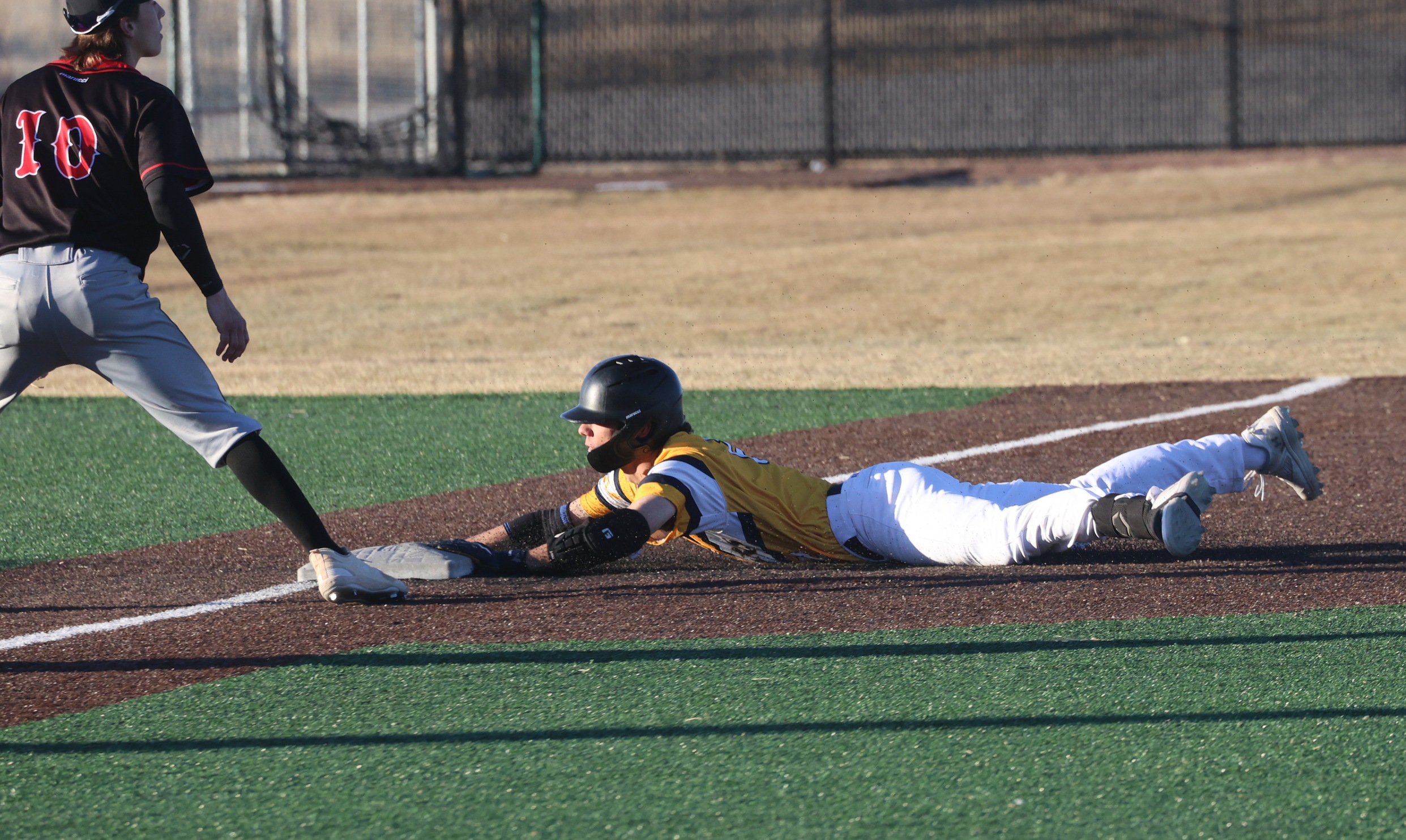 A Cougar runner slides into third in the second game of a doubleheader against Dawson on Sunday.