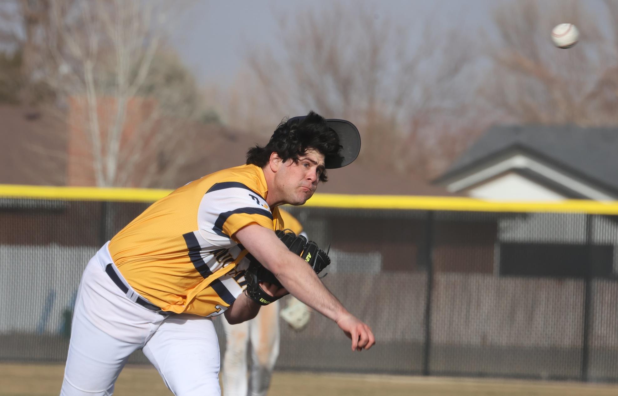 Alex Renfrow delivers a pitch while losing his hat in a day where winds were blowing constantly at 40 mph and players were chasing hats left and right.