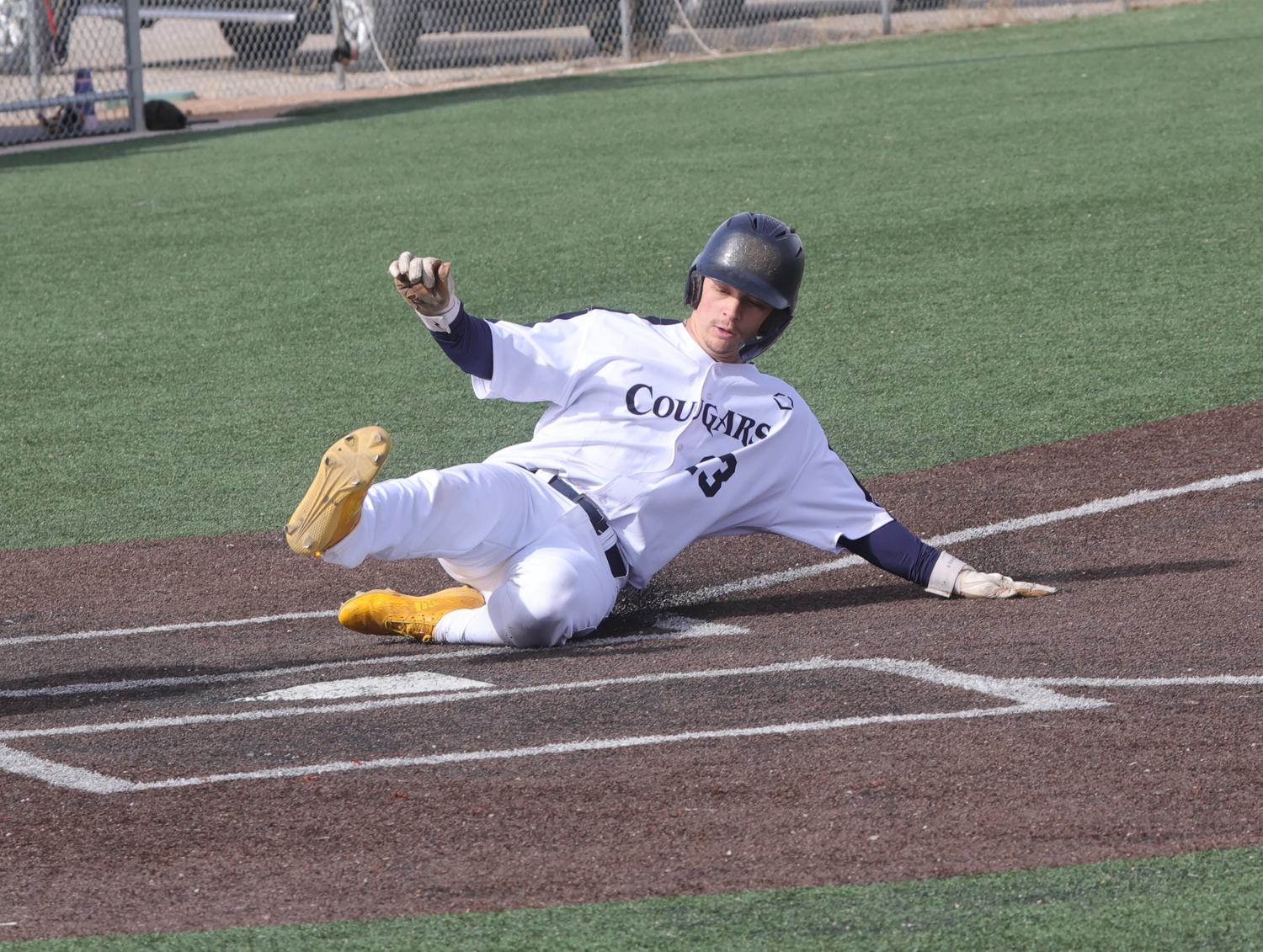 Catcher Gladysh slides into home plate for a run in the first game against Miles on Monday at Cleveland Field.