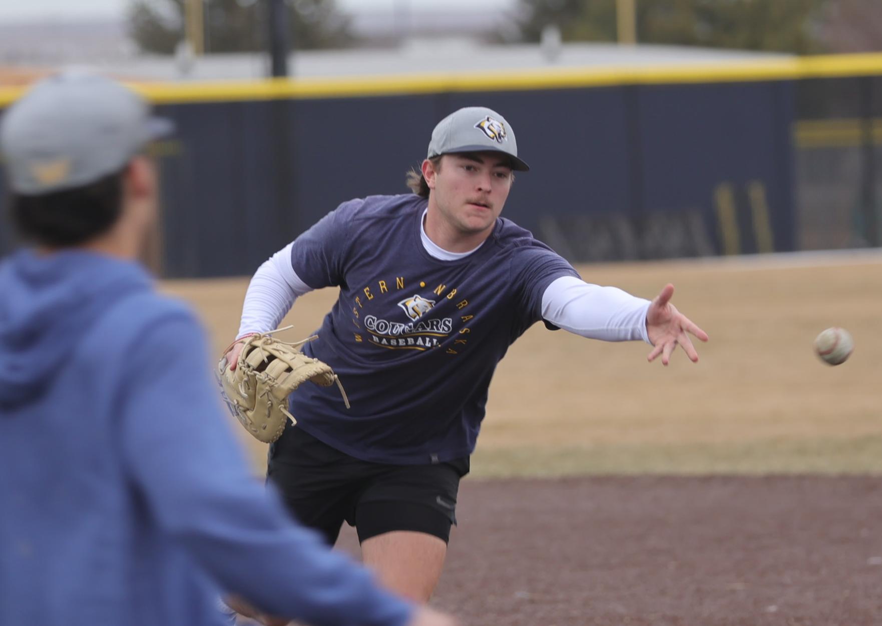 Payton Denning underhanded tosses the ball to first base during an infield drill last week.