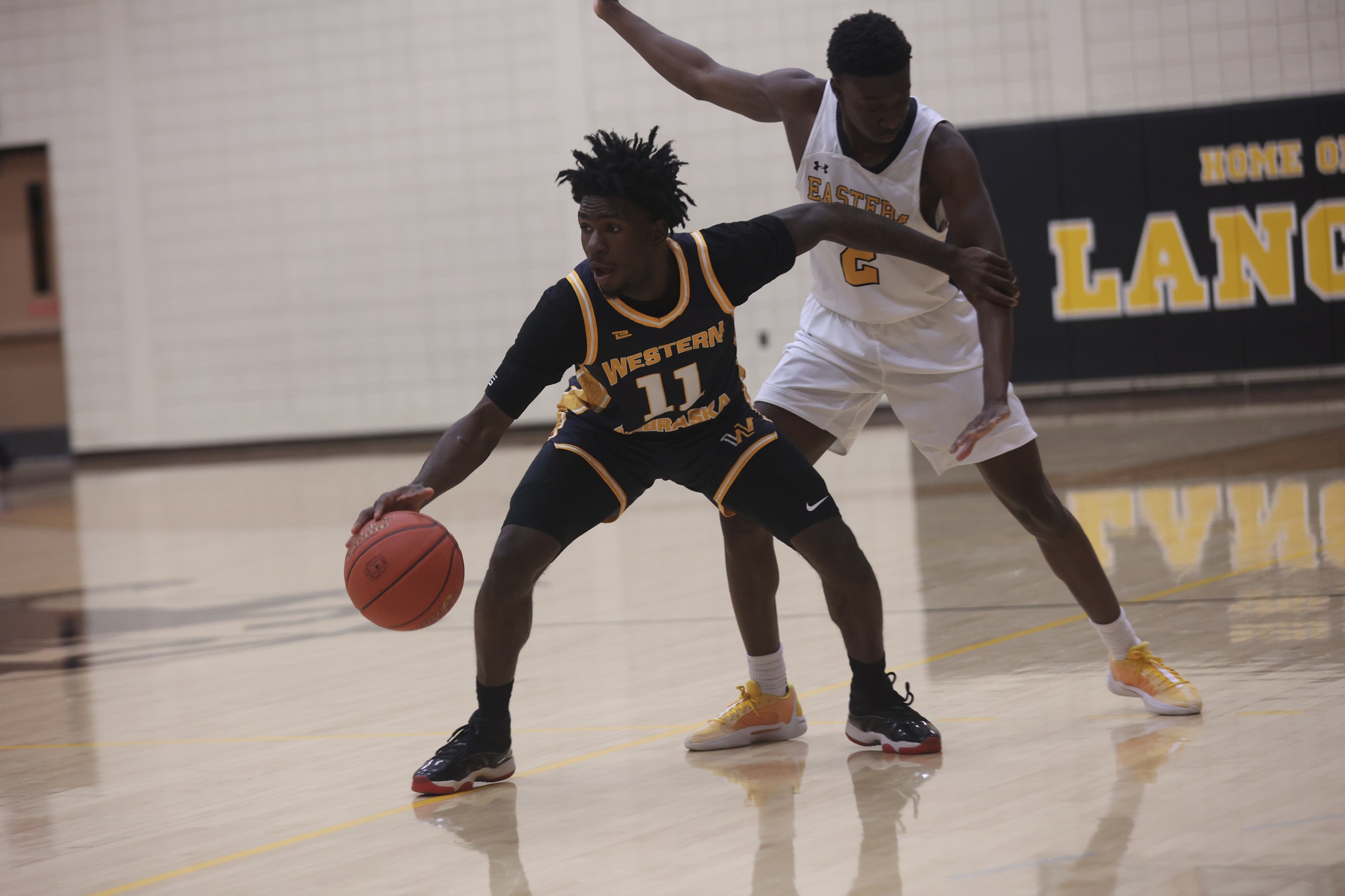 Nazir Griffin blocks out an EWC player while dribbling the ball against EWC on Monday.