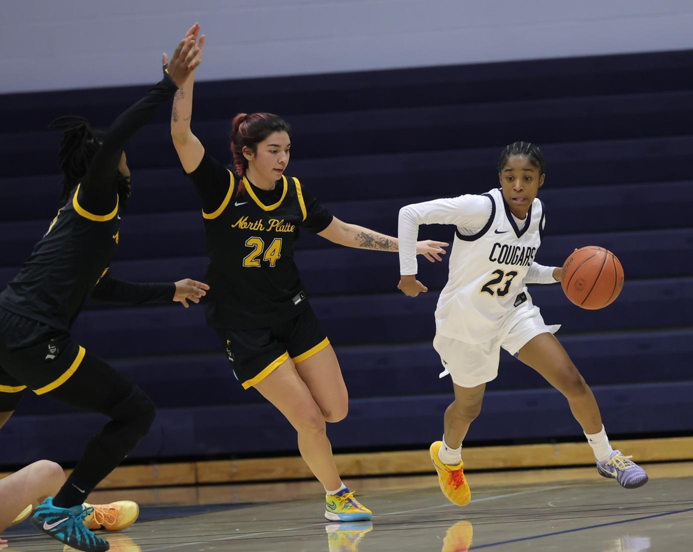 Charisma Johnson brings the ball up the court while getting guarded by North Platte players.