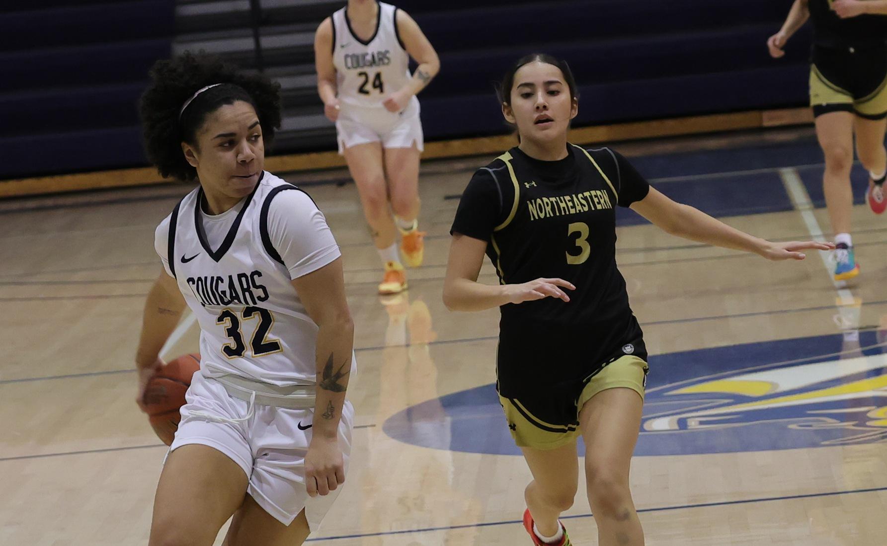 Ella Chesta-Carty delivers a behind-the-back pass to Aniaya Burton-Hernandez in the paint for an easy two points in the Cougars' win over NJC on Saturday.
